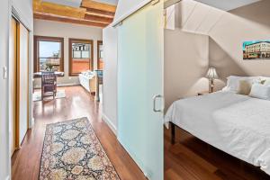 1 dormitorio con 1 cama y pasillo con mesa en The Vogue Loft by Iris Properties!, en Victoria