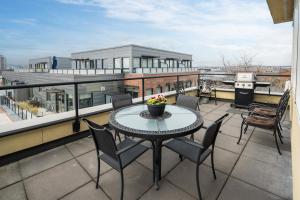 a balcony with a table and chairs on a roof at The Vogue Loft by Iris Properties! in Victoria