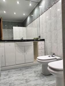 La salle de bains est pourvue de toilettes blanches et d'un lavabo. dans l'établissement Arotzetxea, à Elizondo