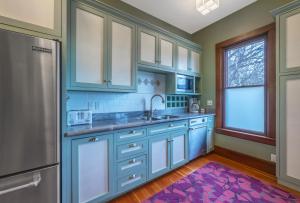 une cuisine avec des armoires bleues et un tapis violet dans l'établissement Historic Roe Parker home, à Hood River