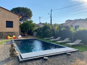 a small swimming pool in a yard with lounge chairs and a buddha statue at Chambre privée in Mandelieu-la-Napoule