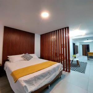 1 dormitorio con 1 cama grande y pared de madera en Monoambiente totalmente equipado, en Santa Cruz de la Sierra