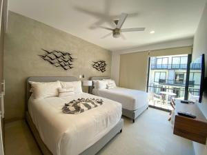 1 Schlafzimmer mit 2 Betten und einem Deckenventilator in der Unterkunft 369 "THE BEST APARMENTS NEAR 5TH AV " UrbanTowers in Playa del Carmen