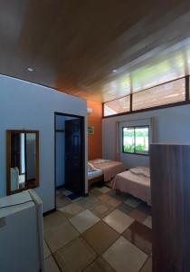 a large room with two beds and a window at Hotel Sunset Rooms in Tortuguero