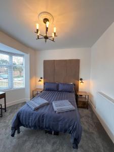 a bedroom with a large bed and a chandelier at No 1 Chestnut Grove in Withernsea