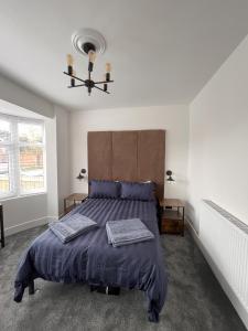 a bedroom with a bed with a blue comforter at No 1 Chestnut Grove in Withernsea