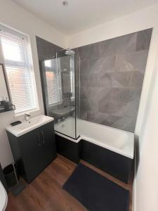 a bathroom with a tub and a sink and a shower at No 1 Chestnut Grove in Withernsea