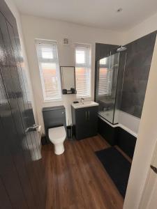 a bathroom with a toilet and a shower and a sink at No 1 Chestnut Grove in Withernsea +18 photos