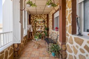 a porch with chairs and plants in a building at Apartamento cerca del hospital Virgen de la Arrixaca in Murcia