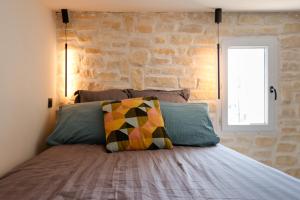 1 dormitorio con 1 cama con pared de piedra en Appartement sous les toits en Antibes