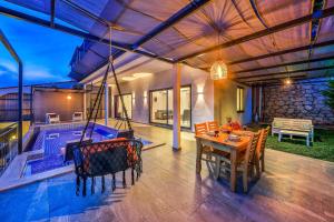 een patio met een tafel en stoelen en een zwembad bij Villa Likya Honeymoon in Kalkan