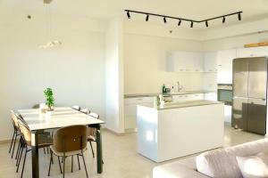 a kitchen and dining room with a table and a refrigerator at Brand New Flat Seaview 4BDR 140m2 in Netanya