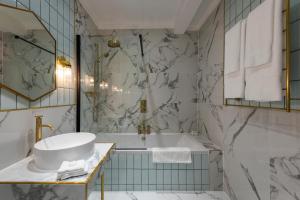 ein Badezimmer mit einer Badewanne, einem WC und einem Waschbecken in der Unterkunft The George Hotel in Buckden
