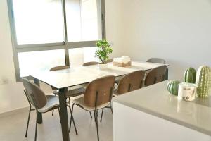 uma mesa e cadeiras numa cozinha com uma janela em Brand New Flat Seaview 4BDR 140m2 em Netanya