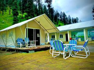 cztery krzesła i stół przed namiotem w obiekcie Valhalla Resort Kumrat w mieście Tāl