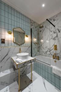 a bathroom with a sink and a tub at The George Hotel in Buckden