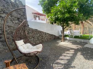 een schommelstoel in een tuin met een boom bij Villa LA RAMA DEL DRAGO, Agaete in San Pedro