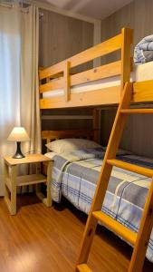 a bedroom with two bunk beds and a lamp at Um Paraiso entre a Floresta e o Mar in São Francisco do Sul