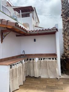 un balcón con cortinas en un edificio blanco en Villa LA RAMA DEL DRAGO, Agaete, en San Pedro
