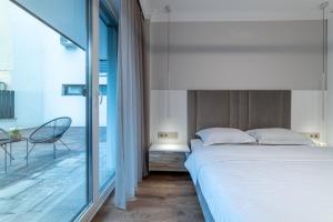 a bedroom with a large bed and a balcony at Opera Apartments in Cluj-Napoca