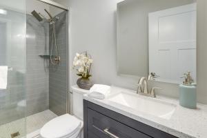 a bathroom with a sink and a toilet and a shower at Modern Traverse City Lake House with Hot Tub! in Traverse City +23 photos