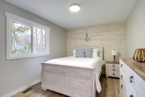 a bedroom with a bed and a window at Modern Traverse City Lake House with Hot Tub! in Traverse City