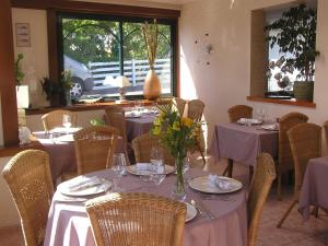 a restaurant with tables and chairs with flowers on them at Les Ondines in Saint-Guénolé