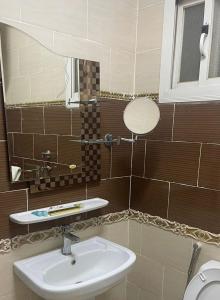 ein Bad mit einem Waschbecken und einem Spiegel in der Unterkunft فندق اوقات الراحة للوحدات السكنيه in Tabuk