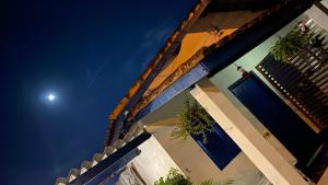 a view of a house with the moon in the sky at Pousada Via Maria in Cananéia