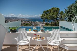 two chairs and a table with food on a balcony at Lagon Life Spirit Boutique Hotel - Adults Only in Chania Town