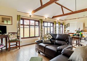 a living room with a leather couch and a table at The White Horse Cottage in Saint James