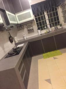 a kitchen with a stove and a counter top at Bougainvillea Botani Home in Ipoh