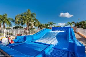 um escorrega de água azul num resort com palmeiras em Beautiful Townhome wPool &FREE Resort Access em Kissimmee