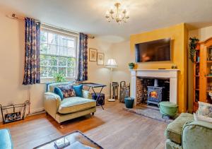 a living room with a couch and a fireplace at Town Cottage in Halesworth