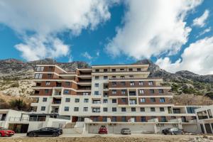 duży budynek z górami w tle w obiekcie Apartment Ava w Kotorze