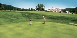 two people standing on a green golf course at mi-clos - luxury pods with private jacuzzis in Orford