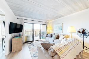 Surfs Edge 108 في آوشين سيتي: غرفة معيشة مع أريكة وتلفزيون بشاشة مسطحة