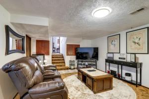 a living room with a leather couch and a table at Spokane Valley Vacation Rental with Shared Pool! in Spokane Valley