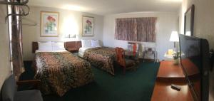 a hotel room with two beds and a flat screen tv at Budget Inn Clearfield PA in Clearfield