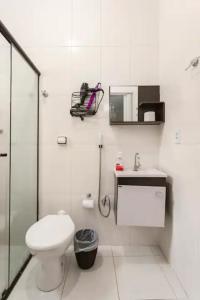 y baño con aseo, lavabo y ducha. en Pousada Casa da Fernanda, Suíte Family, en Praia Grande