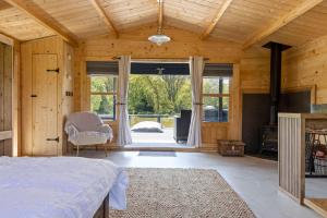 a bedroom with a bed and a large window at Choller Lake Lodges - Sunbeam Cabin With Private Hot Tub in Arundel