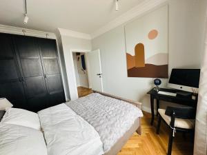 1 dormitorio con cama, escritorio y ordenador en Warsaw Sadyba Premium Apartment by B2, en Varsovia