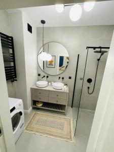 łazienka z prysznicem, 2 umywalkami i lustrem w obiekcie Warsaw Sadyba Premium Apartment by B2 w Warszawie