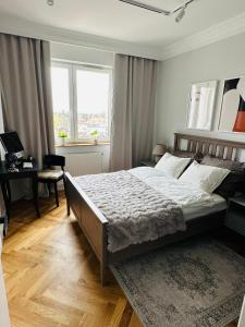 1 dormitorio con 1 cama grande y escritorio en Warsaw Sadyba Premium Apartment by B2, en Varsovia