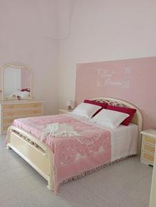 um quarto com uma cama, uma cómoda e um espelho em Da Zia Betty casa vacanza em Maruggio