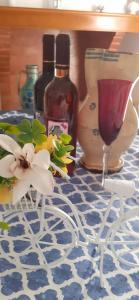 una mesa con dos botellas de vino y una flor en Da Zia Betty casa vacanza, en Maruggio