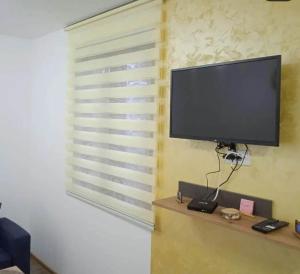 een flatscreen-tv zittend op een muur bij Apartman NIKOLIJA 2 in Kaludjerske Bare