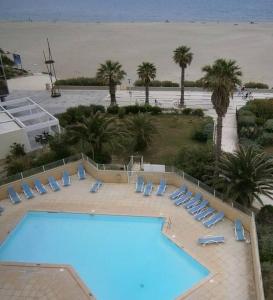 einen großen Pool mit Liegestühlen und Strand in der Unterkunft Canet plage T2 + cabine clim et piscine in Canet-en-Roussillon