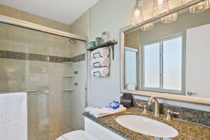La salle de bains est pourvue d'un lavabo et d'une douche. dans l'établissement Beach Bungalow 700, à Jacksonville Beach