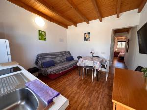 kuchnia i salon z kanapą i stołem w obiekcie Alquilaencanarias Plaza de Alojera 2 w mieście Alojera